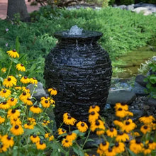 Aquascape Stacked Slate Urn Fountain Kit showing a tall decorative water feature with stacked slate design and flowing water.